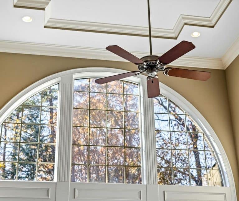 Ceiling Fan installed in high ceiling with feature window on sunny day